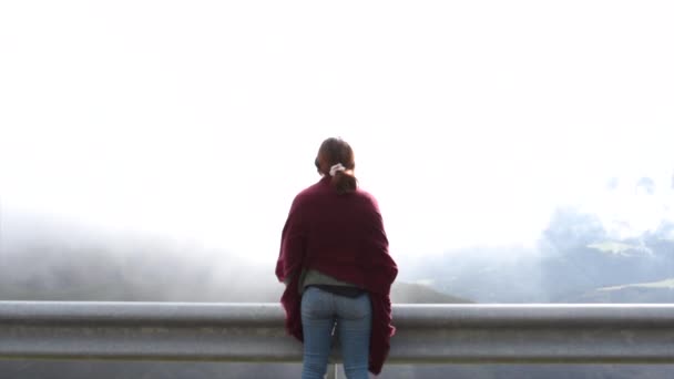 霧の背後にある山を見て月のスカーフを持つ少女 旅行コンセプト — ストック動画