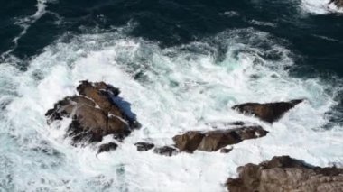 Çok köpüklü deniz dalgaları kayalara çarpıyor Seyahat videosuna çarpıyor