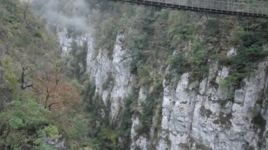 Dağlar ve yürüyen bir çift arasındaki köprünün üstünden görünüm - seyahat kavramı