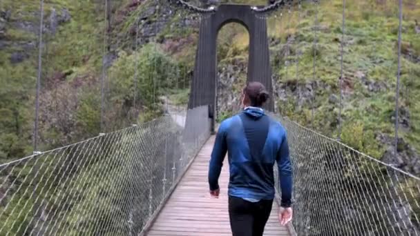西班牙一座山桥上行走的身穿蓝色运动衫的肌肉男 旅行理念 — 图库视频影像