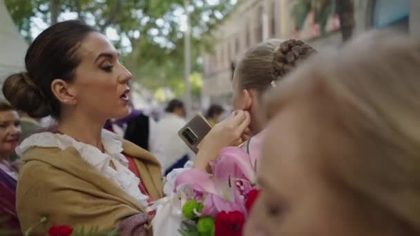 別の女性にイヤリングを与える彼女の手に携帯電話を持つブルネットの女性 スペインの伝統 — ストック動画