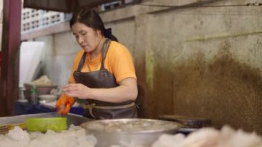 Taylandlı balık satıcısı, karidesleri evdeki iş yerinde satmadan önce onları soyuyordu.