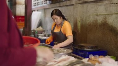 Taylandlı balıkçı, Tayland 'ın Bangkok şehrinde deniz ürünlerini tartıyor ve plastik sepet kullanıyor.