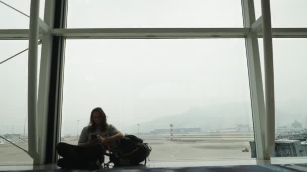 Jeune Homme Hispanique Assis Sur Une Fenêtre Aéroport Prenant Selfie — Video