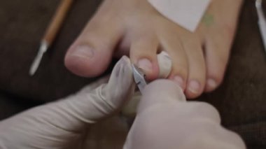 Professional dead skin, cuticle and nail trimming by a nail salon professional - Health concept