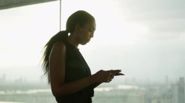 Black digital nomad woman using a training app in his rooftop gym - Lifestyle concept