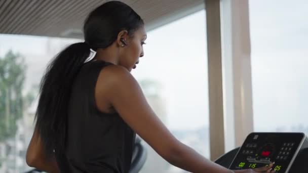 年轻的黑人妇女在曼谷的摩天大楼体育馆里设置跑步机 生活方式的概念 — 图库视频影像