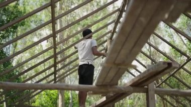 Construction worker fixing a wood stick from a new home - 4K Horizontal video