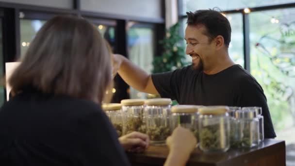 Gülümseyen Genç Yetişkin Marihuana Çiçeklerini Seçmek Için Bir Perakendeciyle Konuşuyor — Stok video