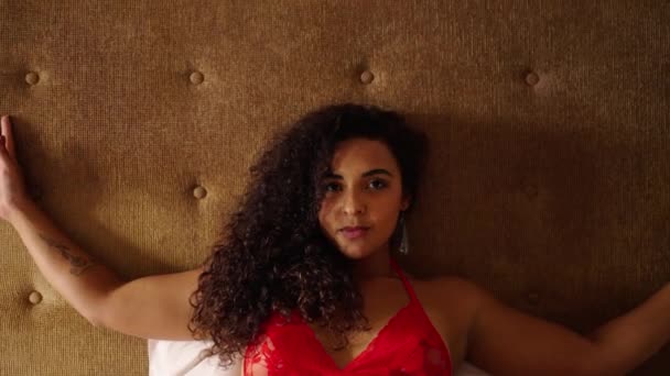 Kıvrımlı Esmer Kız Yatağında Uzanıp Kameraya Bakıyor — Stok video