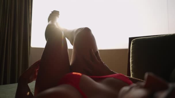 Altın Tenli Kadın Arka Plandaki Pencere Işığıyla Bacaklarına Dokunuyor — Stok video