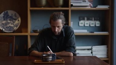 Batılı çocuk cep telefonuna bakar ve tabletine resim çizer.