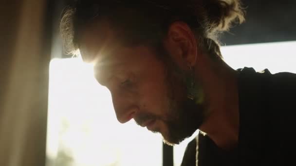 Mann Mit Bart Und Ethnischem Ohrring Blickt Auf Etwas Unten — Stockvideo