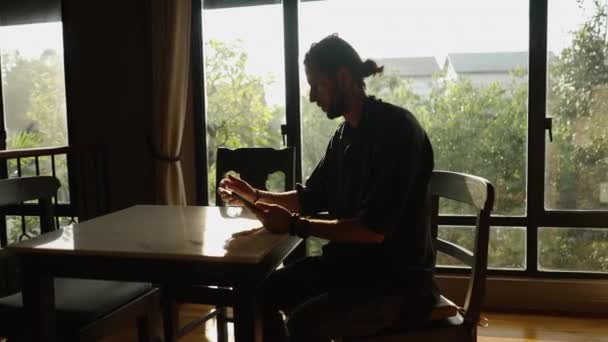 Western Garçon Regarde Tablette Marque Quelque Chose Côté Une Fenêtre — Video