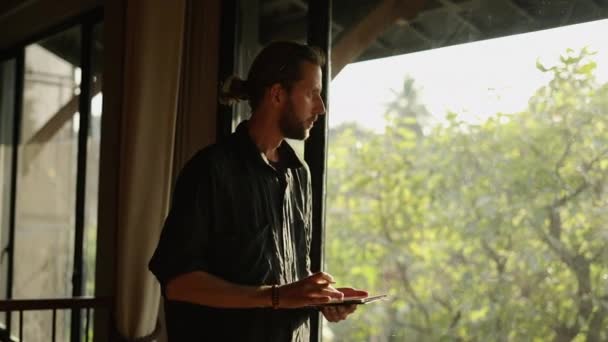 Lanky Bearded Man Looking Window His Tablet His Hand Online — Stock Video