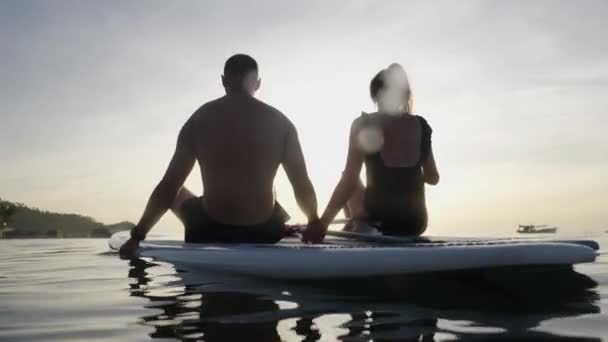Dos Adultos Boca Arriba Mirando Puesta Sol Sus Tablas Mar — Vídeos de Stock
