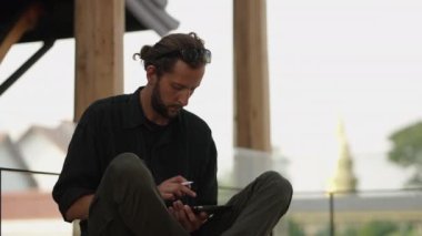 Batılı yetişkin adam tabletine bir şeyler çiziyor.