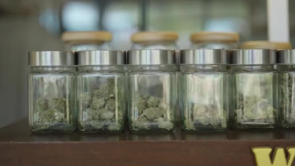 Slide Shot Frascos Cristal Llenos Marihuana Medicinal Una Tienda Marihuana — Vídeo de stock