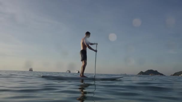 Západní Muž Pádlování Vrcholu Jeho Pádlo Surfovací Prkno Moři Pár — Stock video