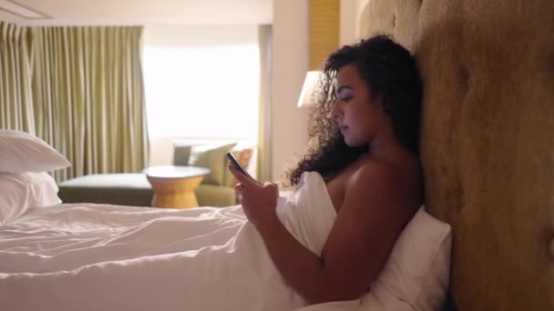 来自南美洲的女孩在床上用手机发短信 身体呈阳性 — 图库视频影像