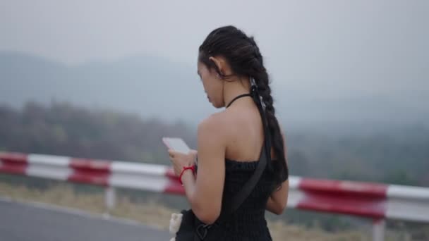 黒い服を着たポニーテールの女の子は 彼女の携帯電話を見ます ワンダラー — ストック動画