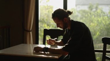 Gözlüklü ve sakallı Batılı çocuk tabletine dokunuyor.