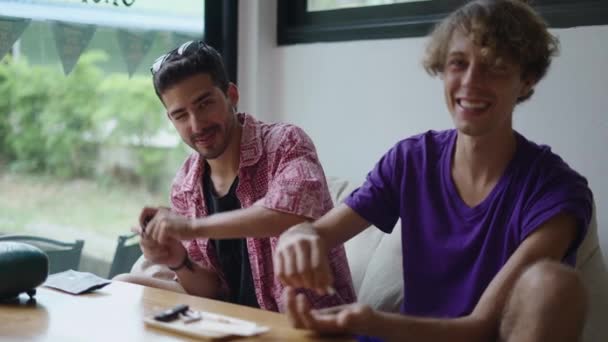 Zwei Kaukasisch Lächelnde Männer Blicken Die Kamera Während Sie Einen — Stockvideo