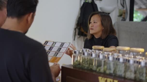 顾客在大麻商店里看大麻花菜单 新的商业概念 — 图库视频影像
