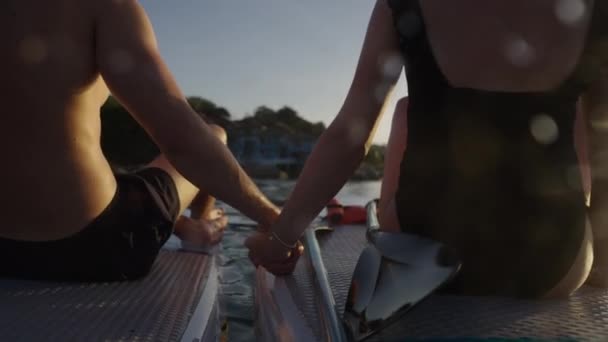 コーカサスカップルは 水の中の夕日を見るように手を握る カップル旅行のコンセプト — ストック動画