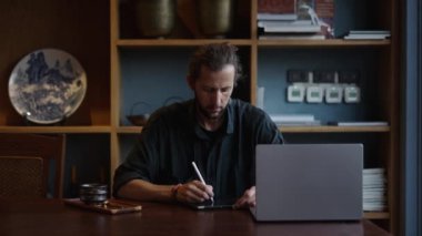 Kafkasyalı tasarımcı bilgisayarına bakarken tabletine bir şey yazıyor - internet işçisi