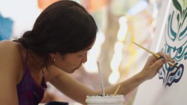 Güzel kadın ressam bir çizim üzerinde yoğunlaşıyor - Hippi ressam