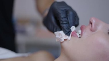 Doktor, titreyen kızın dudak bölgesini temizliyor - sağlık konsepti