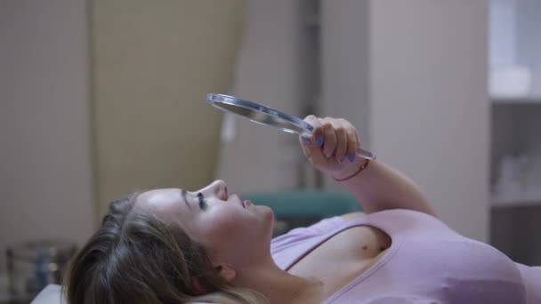 Hermosa Mujer Rubia Mira Espejo Después Del Tratamiento Labial Concepto — Vídeos de Stock