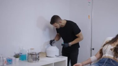 Doktor, hasta telefonuna bakarken santrifüje kan tüpleri koyuyor. 4K yatay video.