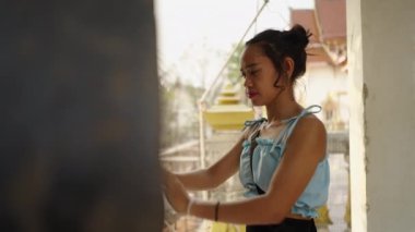 Asyalı kadın tapınağın ortasında gong çalıyor - Budist konsepti