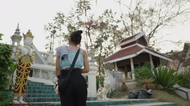 ブルネットの女性がタイの寺院で階段を登る 仏教の概念 — ストック動画