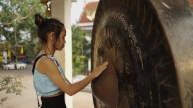 Taylandlı kadın bir tapınakta gong ritüeli gerçekleştiriyor - Budist konsepti