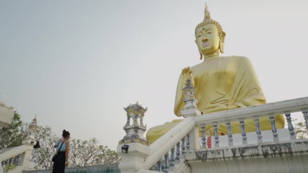 一个女孩在一座神圣的黄金纪念碑前祈祷 佛教的概念 — 图库视频影像