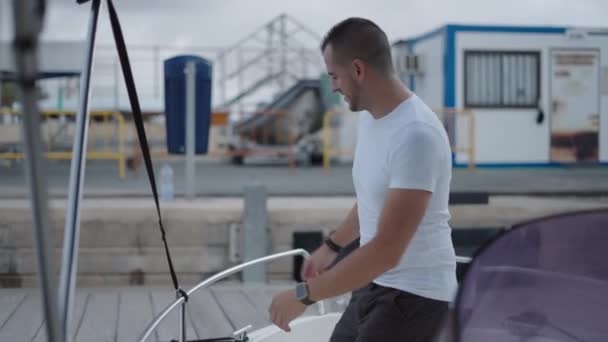 一个白人男人从他的船上卸下系泊物 奢侈的生活方式 — 图库视频影像