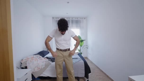 ラテン系男性は白いポロシャツの首を調整します 4K水平ビデオ — ストック動画