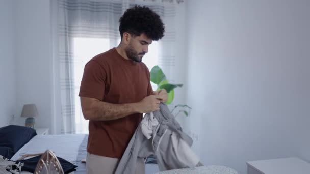 Homme Latin Concentre Sur Repassage Son Pantalon Vidéo Horizontale — Video