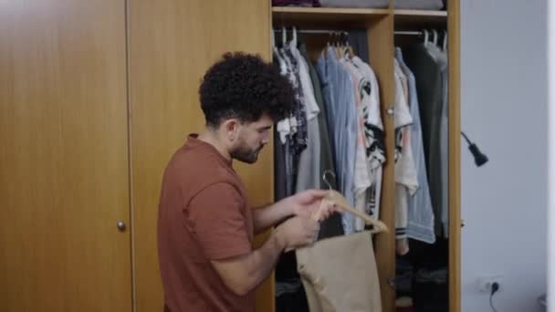 Homem Latino Abre Seu Guarda Roupa Tira Par Calças Camelo — Vídeo de Stock