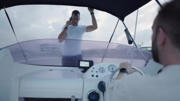 Ein Junge Fährt Ein Boot Während Sein Freund Telefoniert Luxusleben — Stockvideo