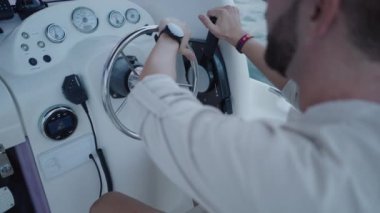 Lüks bir hayat tarzı olan bir adam tarafından kullanılan bir teknenin direksiyon simidine yakın çekim.
