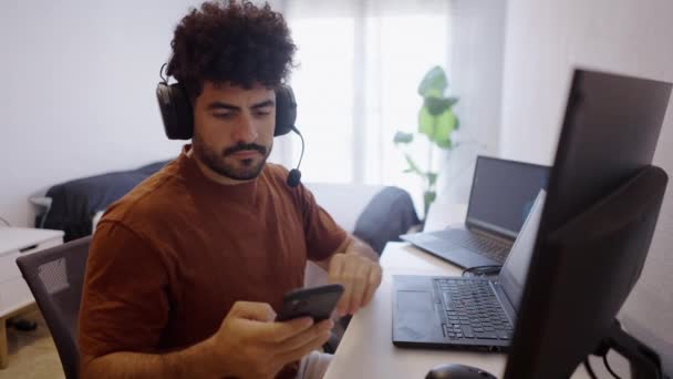 ベネズエラの少年は自宅で働いている間に音楽を演奏するために携帯電話を取ります 4K水平ビデオ — ストック動画