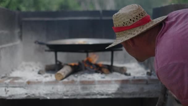 Nierozpoznawalny Mężczyzna Różowej Koszulce Kontroluje Pożar Paelli Hiszpańskie Tradycyjne Jedzenie — Wideo stockowe