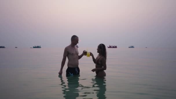 Ein Paar Wasser Trinkt Bei Sonnenuntergang Ein Bier Horizontal — Stockvideo