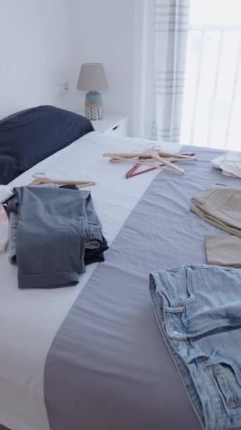 明るい部屋のベッドの衣類のいくつかのアイテム Fhd 垂直ビデオ — ストック動画