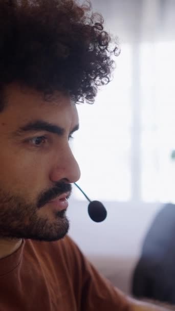 Przystojny Brodaty Mężczyzna Pracuje Domu Rozmawiając Słuchawkami Fhd Vertical Video — Wideo stockowe