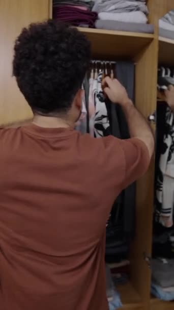 Venezolanischer Junge Zieht Bedrucktes Hemd Aus Dem Kleiderschrank Fhd Vertical — Stockvideo